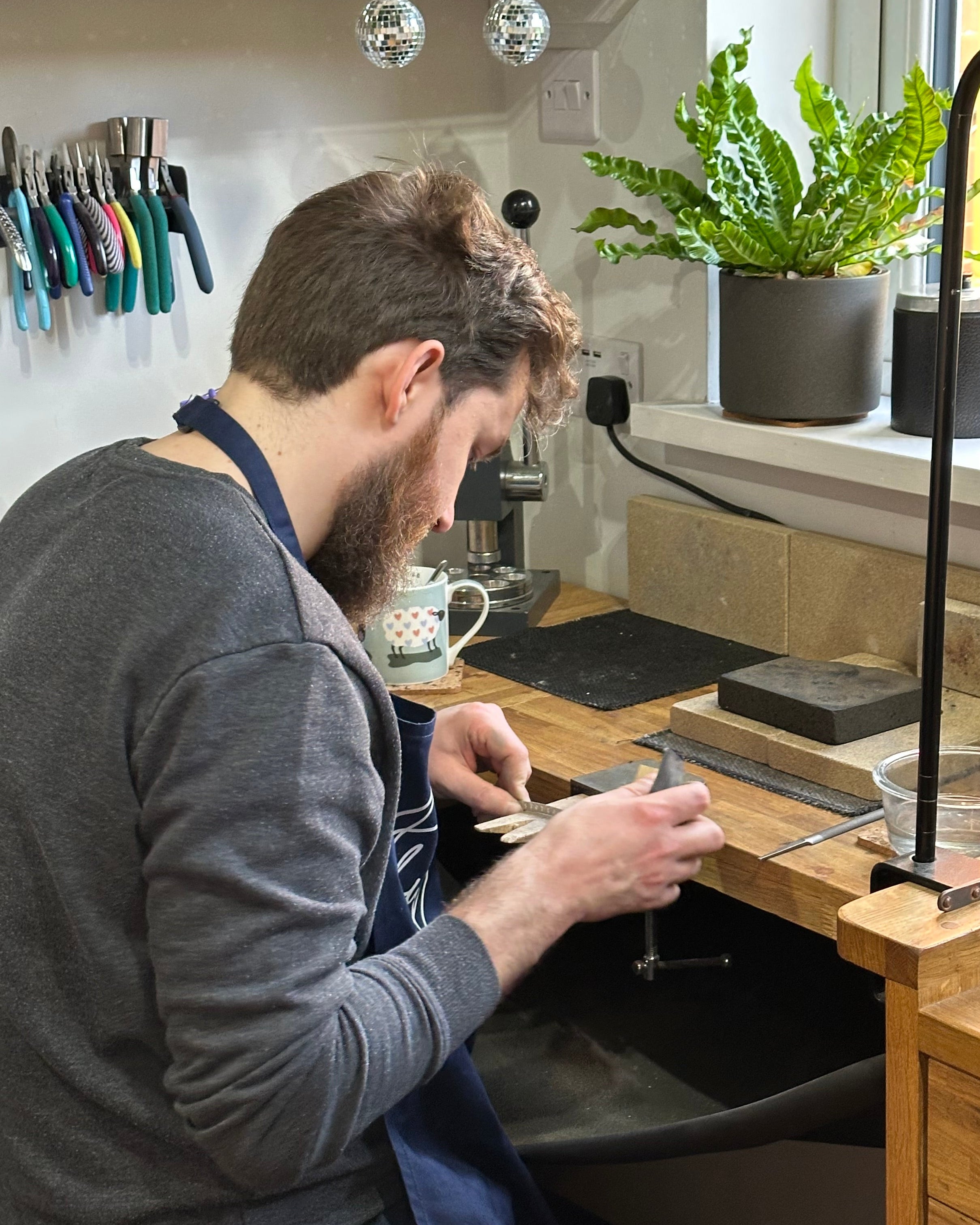 Man making jewellery at a workbench
