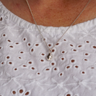 Silver geometric pendant on silver chain, shown on a model.