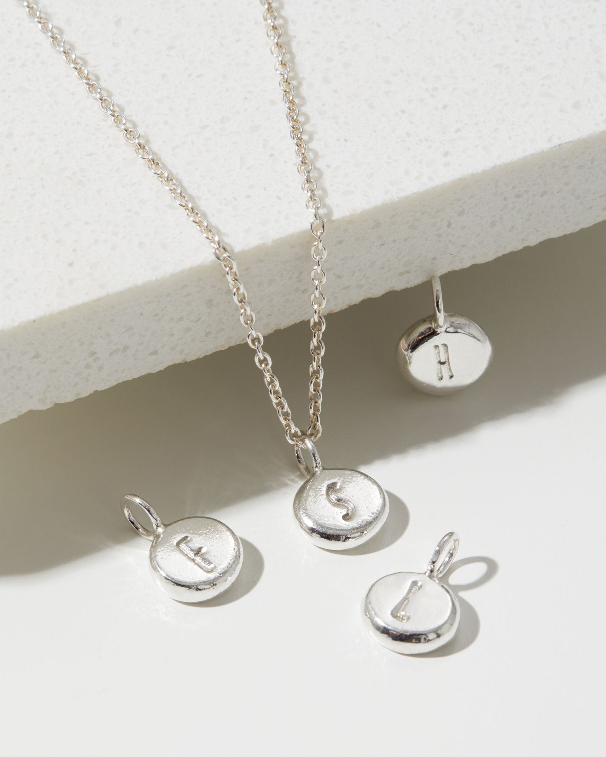 Silver necklace with round pendants on a light background