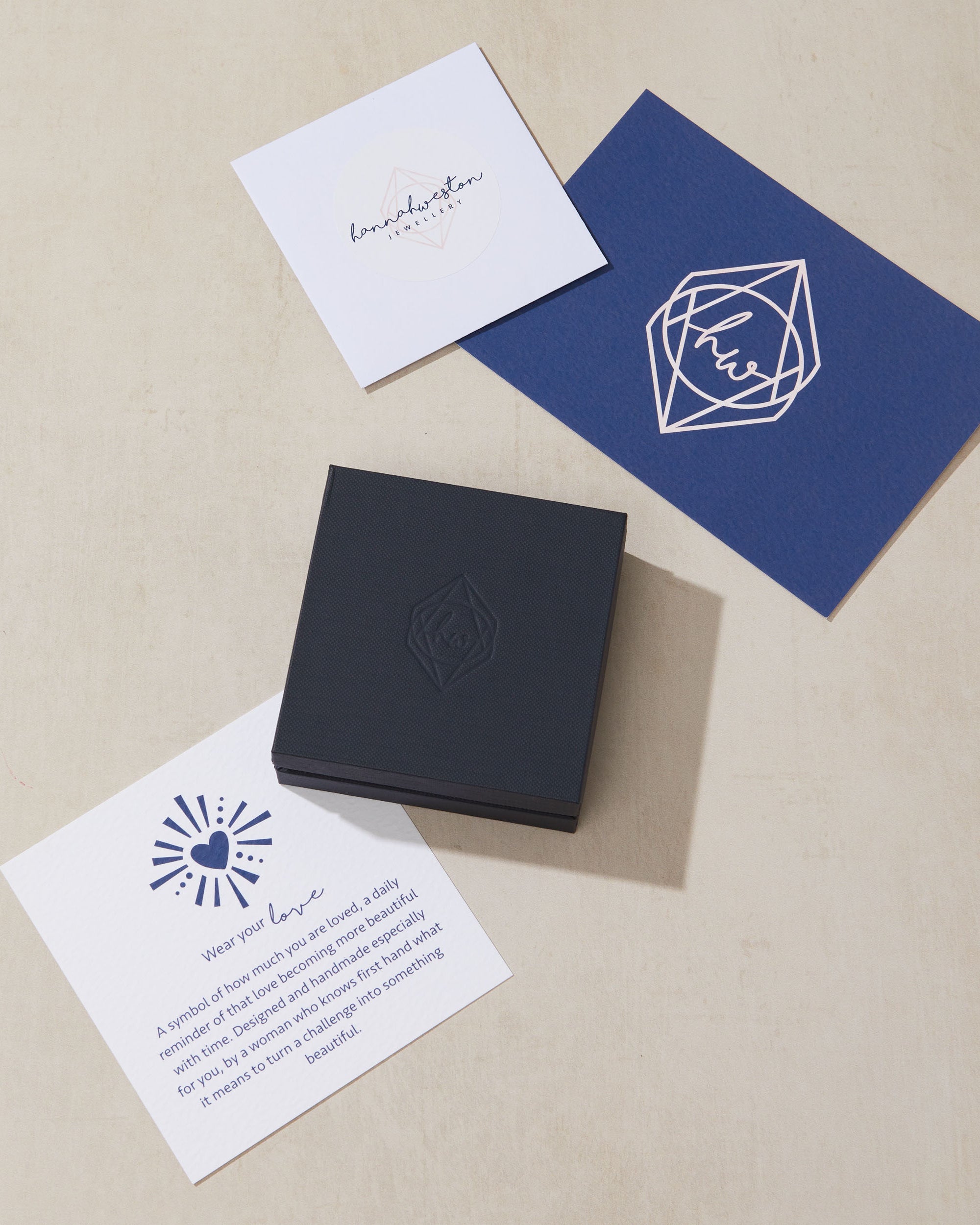 Set of branded cards and a blue box on a beige surface