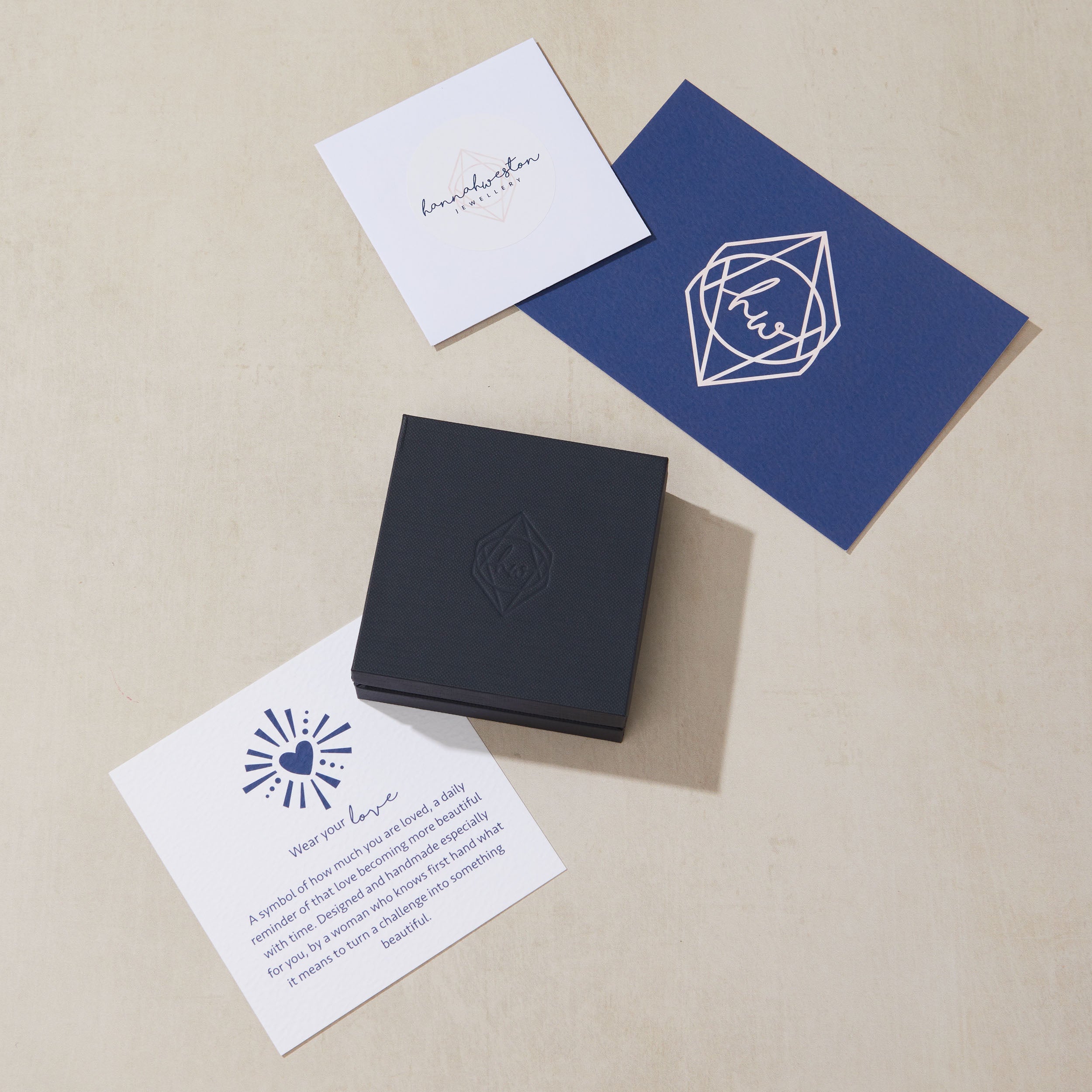 Set of branded cards and a blue box on a beige surface
