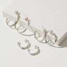 Set of silver hoop earrings on a white surface
