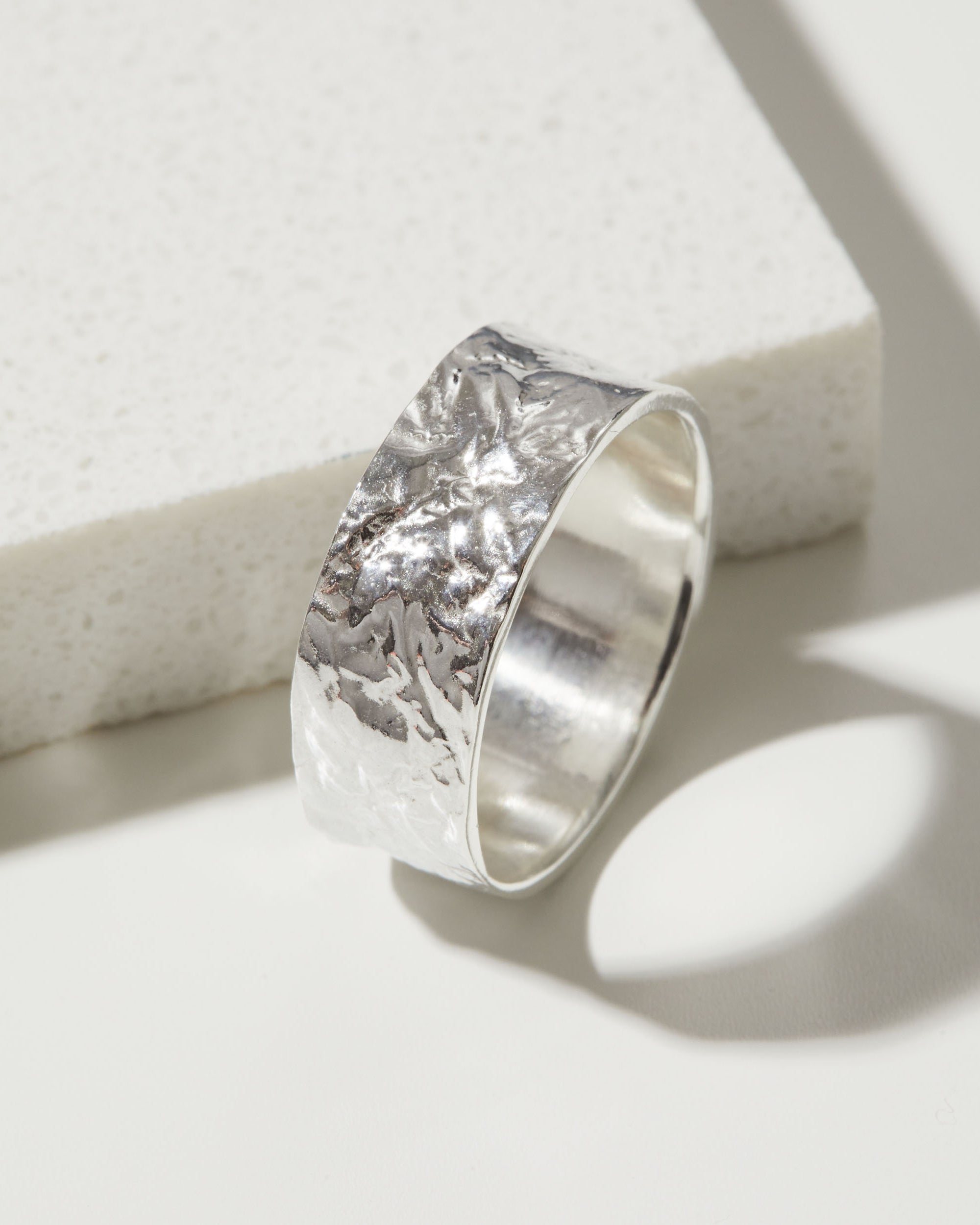 Silver bark textured ring band on a white background.