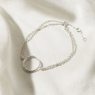 Silver bracelet with a circular design on a light background