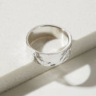 Silver ring with a bark textured surface on a light background