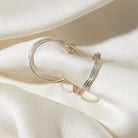 Silver hoop earrings on a white fabric background