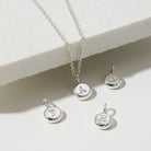 Silver necklace with letter pendants on a light background