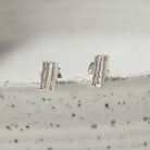 Pair of silver earrings on a textured surface