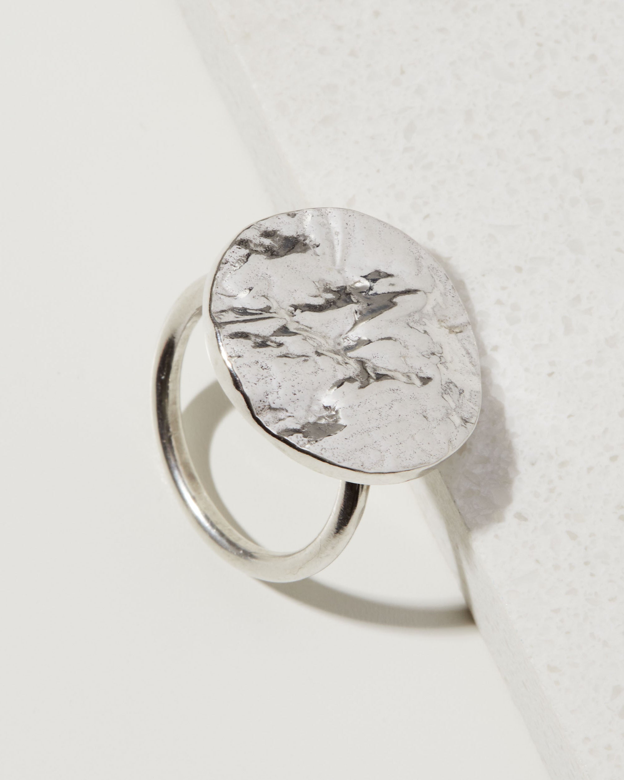 Silver statement tree bark textured ring on a white surface