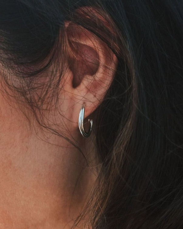 Close-up of an ear with a silver hoop earring