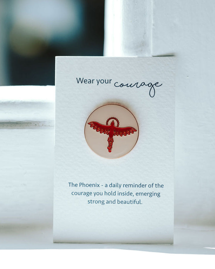 Phoenix on a pin pin badge on a white card.