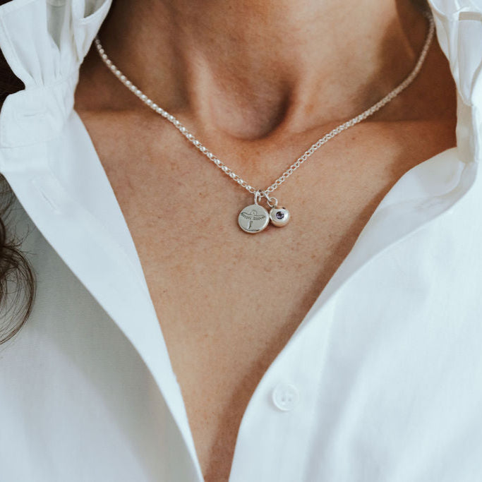Necklace with phoenix and birthstone pendants on a person wearing a white shirt