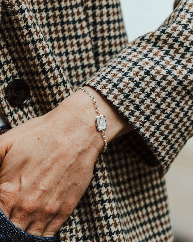 woman wearing a sterling silver bracelet with a feather motif