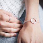 Woman wearing open circle sterling silver handmade bracelet and ring by Hannah Weston.