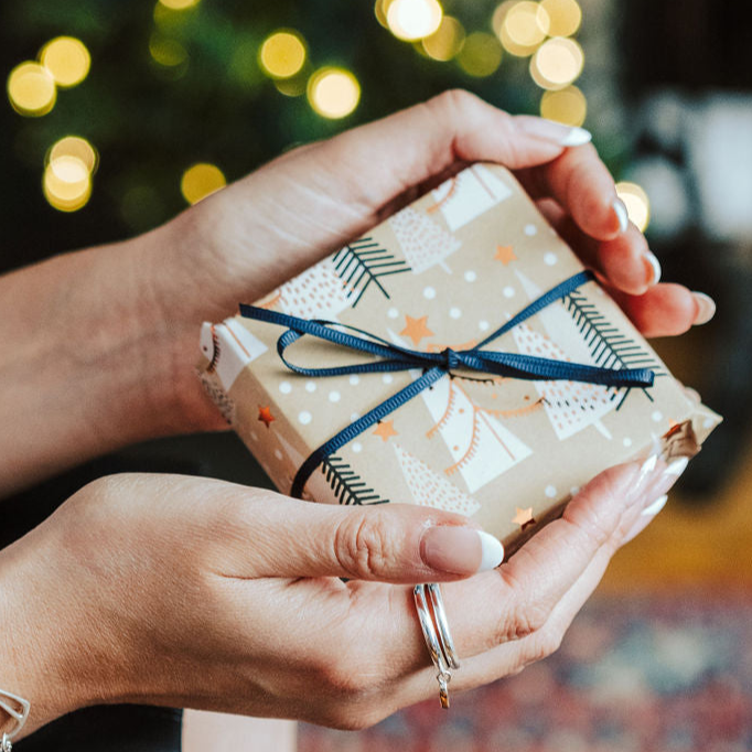Jewellery, boxed and wrapped in Christmas paper with a blue ribbon.