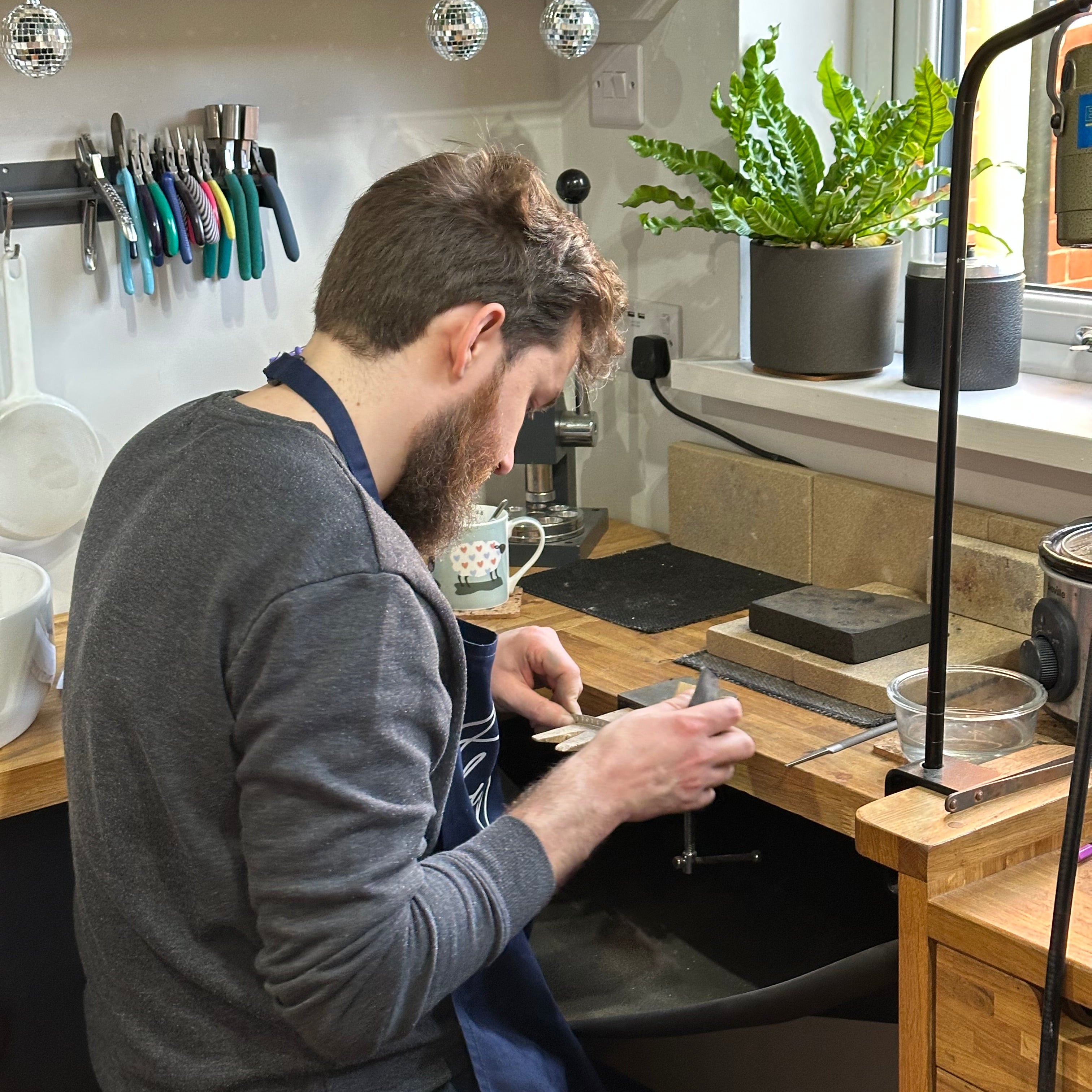 Man making jewellery at a workbench