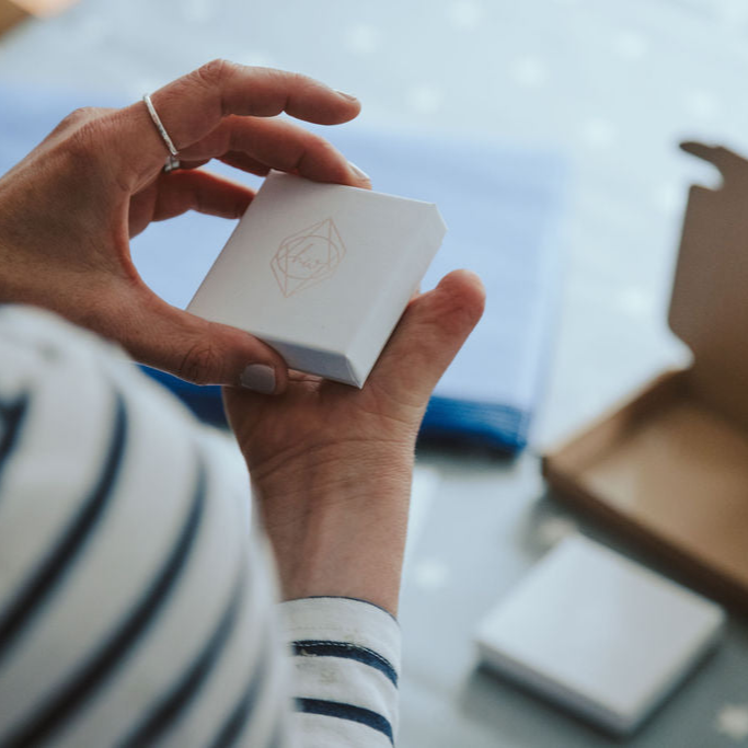 Hannah holding a white, embossed Hannah Weston Jewellery gift box.