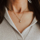 Lady wearing gold pebble pendant set with birthstone.