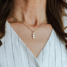 Tree Textured Necklace with a bar pendant worn by a person with wavy hair.