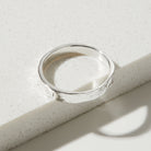 Silver bark textured ring on a textured white surface