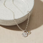 Silver necklace with two pendants on a textured surface