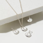 Silver necklace with round pendants on a light background