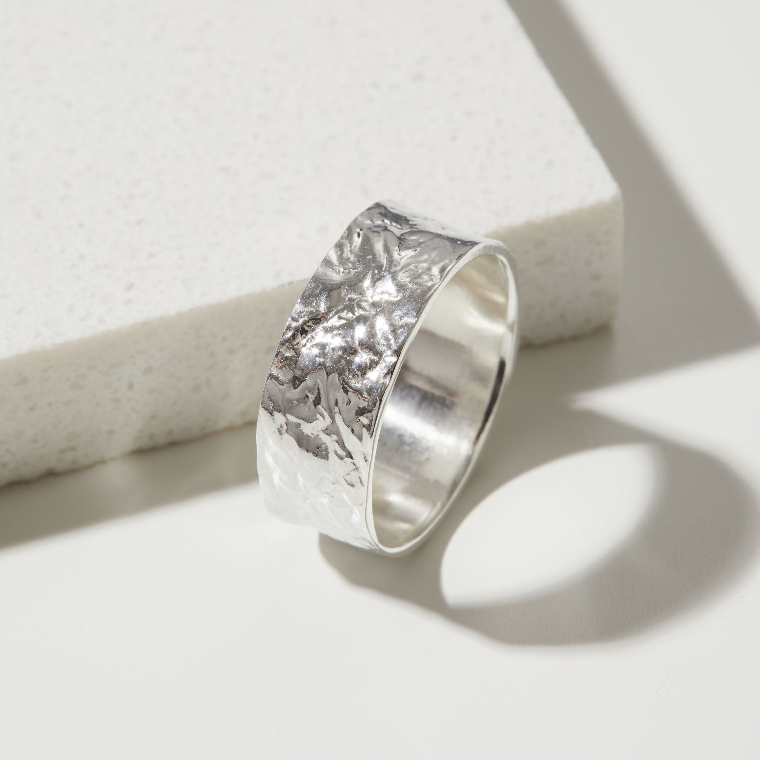 Silver bark textured ring band on a white background.