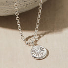 Silver pebble necklace stamped with a heart design.