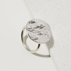 Silver statement tree bark textured ring on a white surface