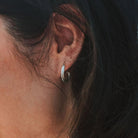 Close-up of an ear with a silver hoop earring