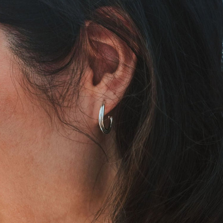 Close-up of an ear with a silver hoop earring