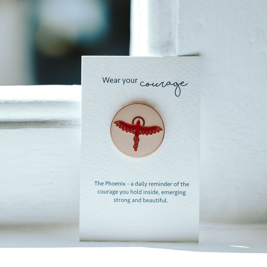 Phoenix on a pin pin badge on a white card.