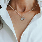 Necklace with phoenix and birthstone pendants on a person wearing a white shirt