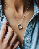 Woman in a denim shirt wearing an entwined circles necklace