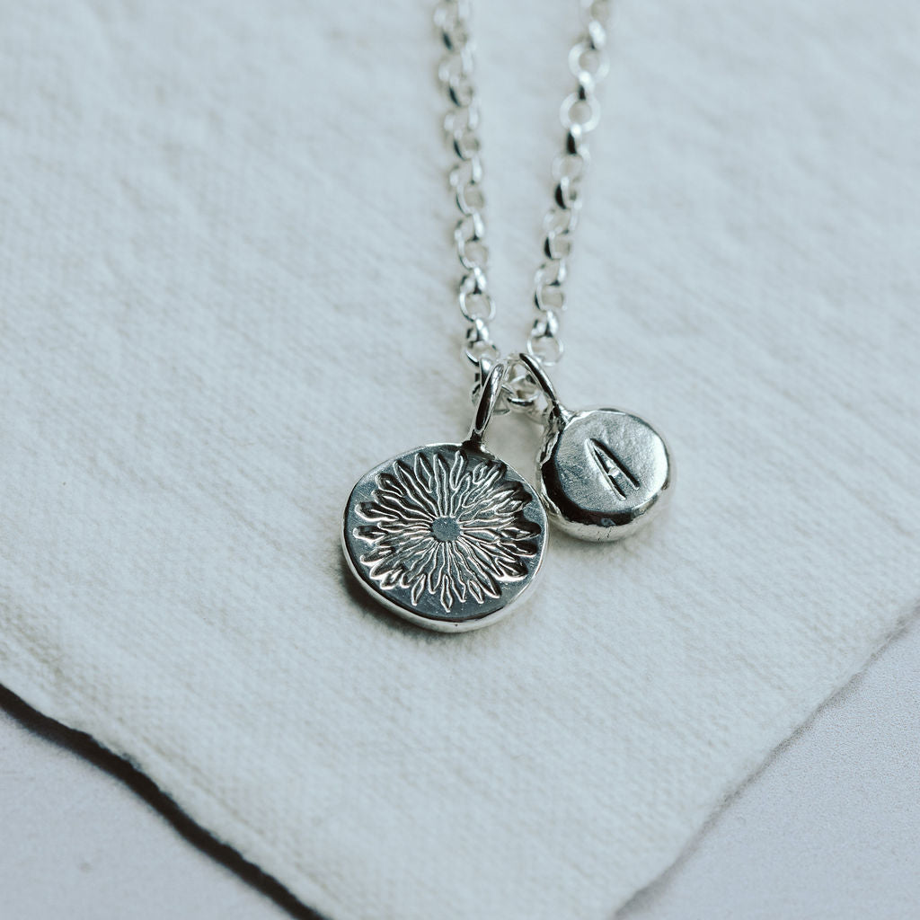 Silver necklace with two pendants on a white background