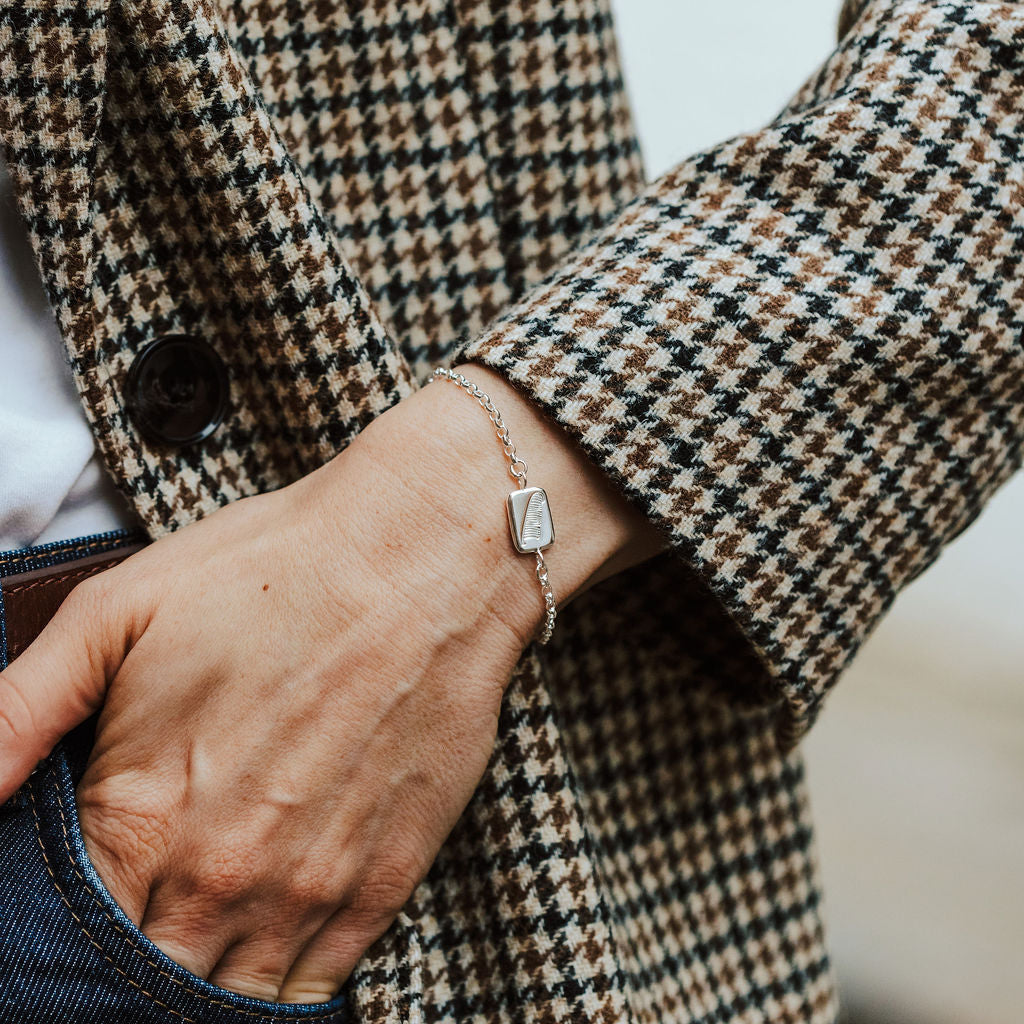 woman wearing a sterling silver bracelet with a feather motif